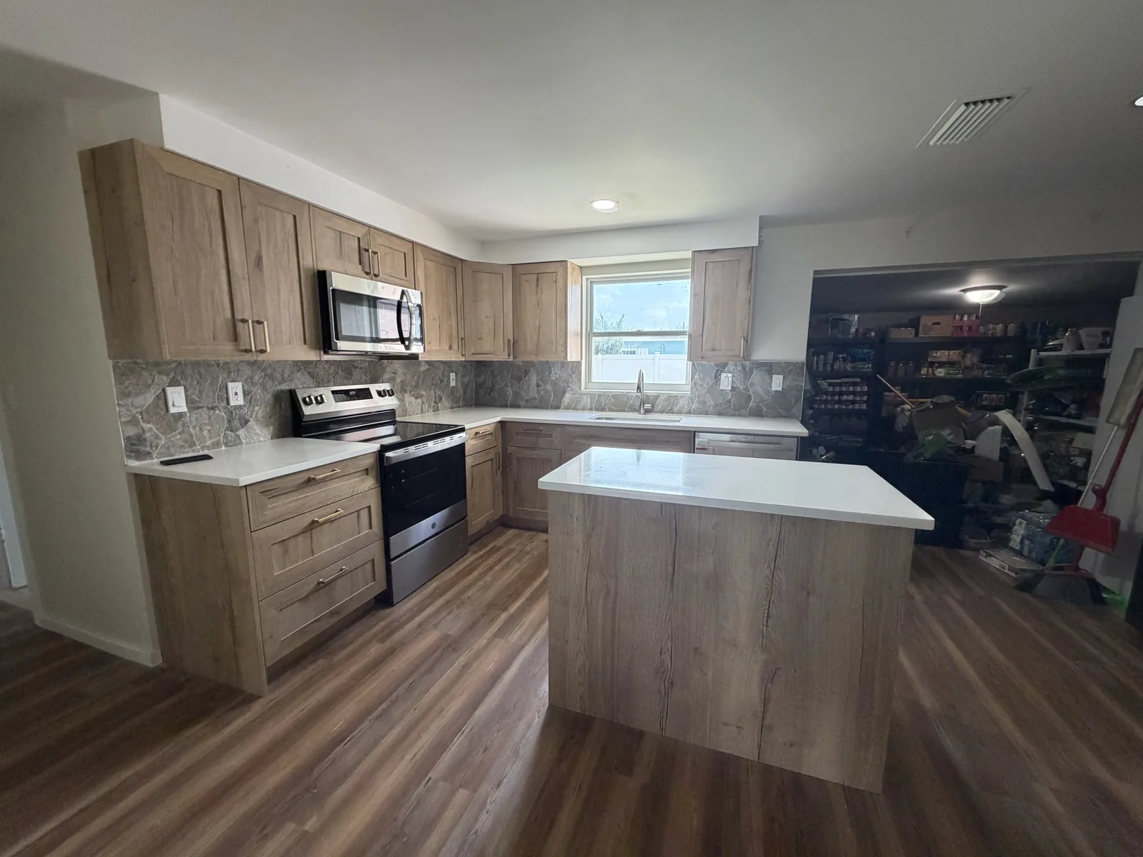 Wood-look plank flooring running through a remodeled kitchen and into the adjoining room