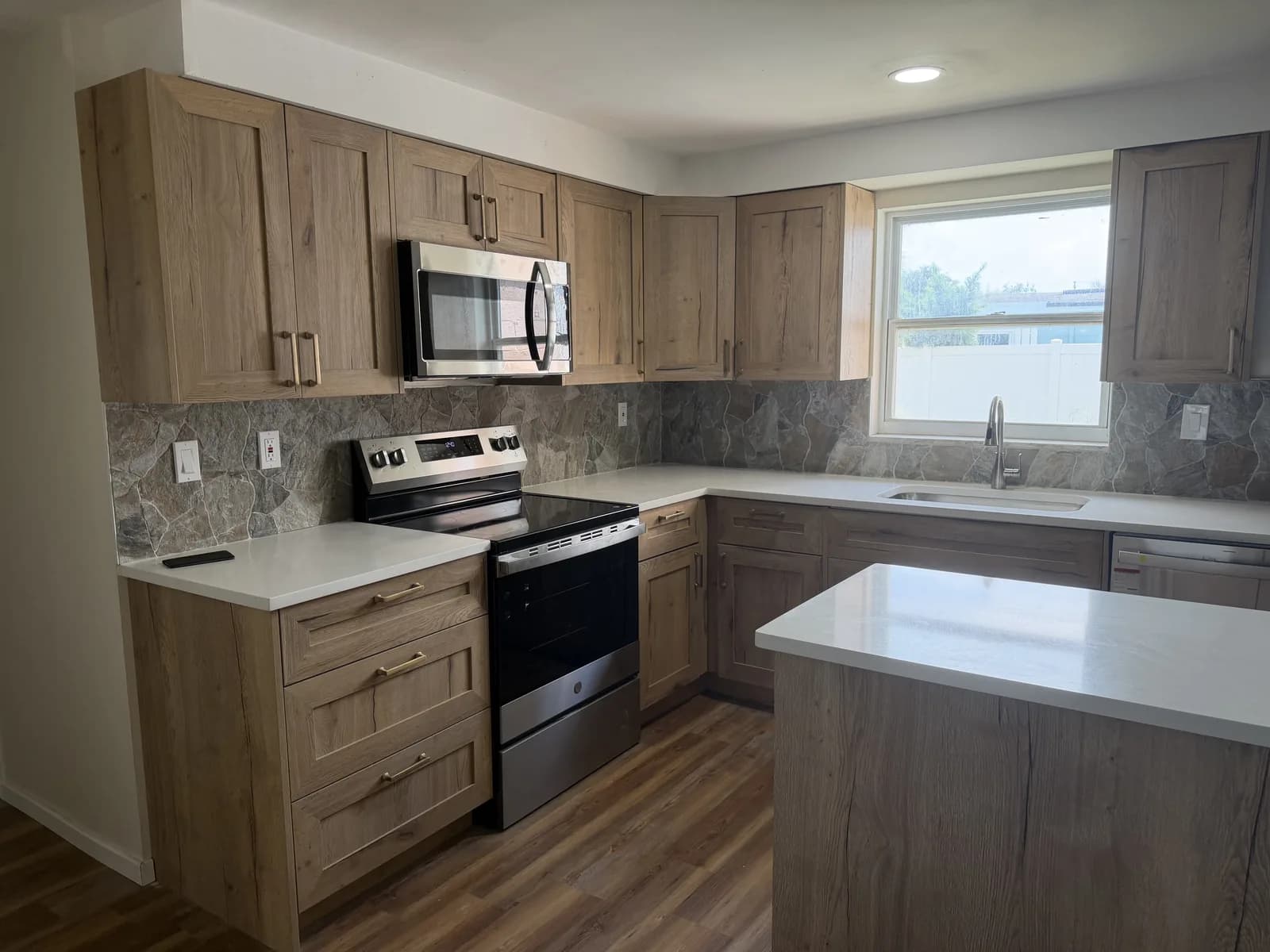 Grey marbled tile backsplash carried across a kitchen wall between counter and wall cabinets