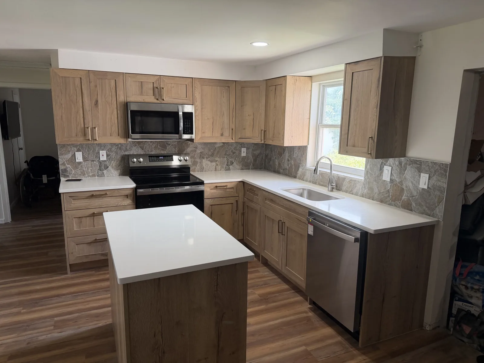 Kitchen with refaced cabinet doors in a natural wood finish, existing layout retained