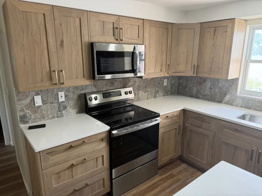 Close-up of a grey marbled tile backsplash behind a stainless range, with quartz counters either side